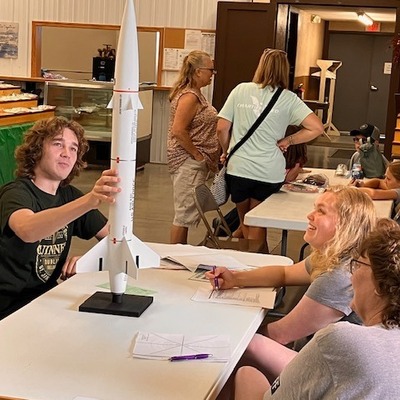 County Fair- 4-H Member showcasing his rocket to judges